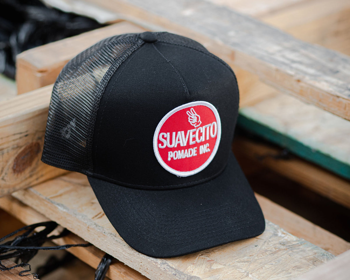 black suavecito hat with white embroidered text and red background "suavecito pomade inc."
