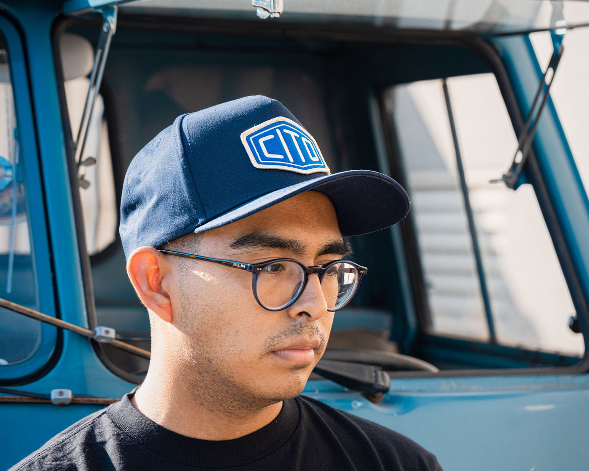 man wearing - blue suavecito hat with white embroidered text and blue background "cito"